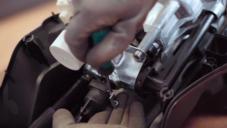 To disconnect the motor, first remove the motor retaining clip with your flatblade screwdriver.