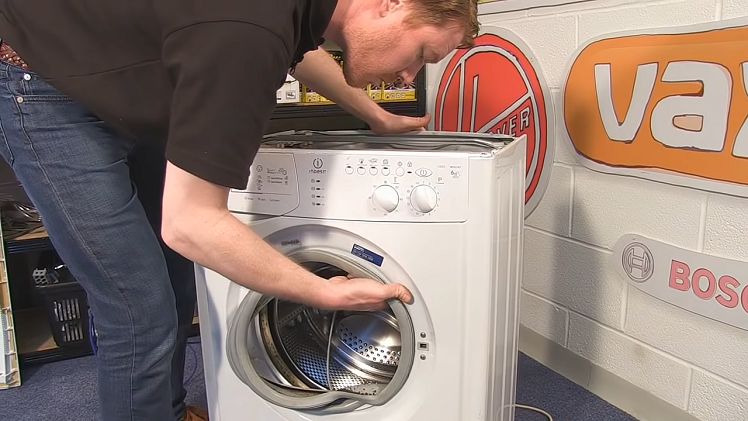Reach inside and pull the door seal and the inner retaining band out of the washing machine together.