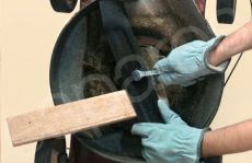 Wedging The Lawnmower Blade With A Piece Of Wood To Help Prevent The Blade From Possibly Moving