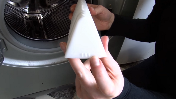 Make sure the side with the three small bumps is facing the front of the washing machine.