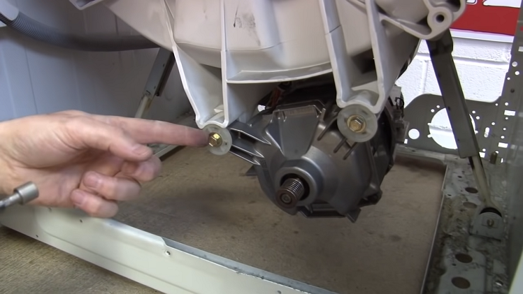 To remove the motor itself, remove the two bolts that hold it in place beneath the tub.