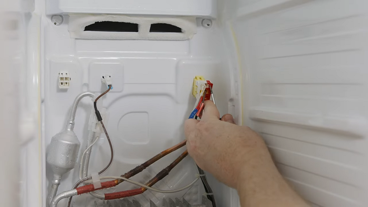 Releasing The Red And White Retaining Clips With A Flathead Screwdriver To Remove The Right Hand Plug On The Defrost Heater Terminals