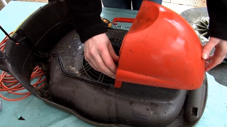 Lift the motor cover off the lawnmower and place it aside