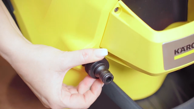 Unscrew and remove the small black water inlet hose connection located at the bottom front of the pressure washer.