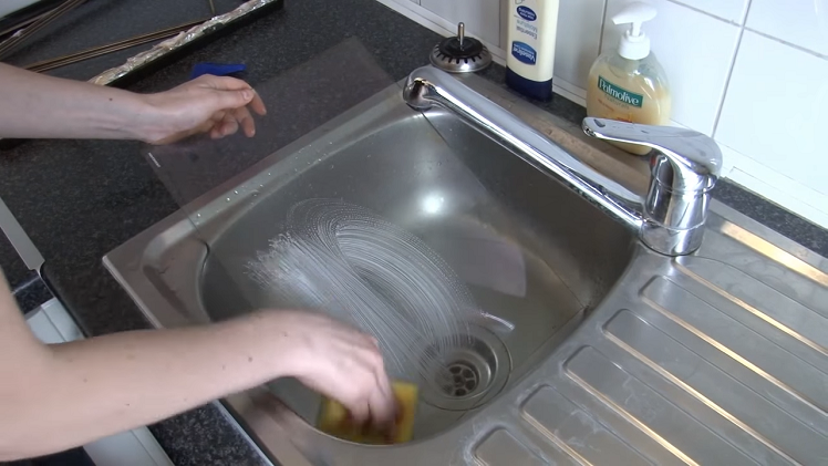 Scrubbing The Two Sheets Of Door Glass In A Sink With A Sponge And Household Detergent