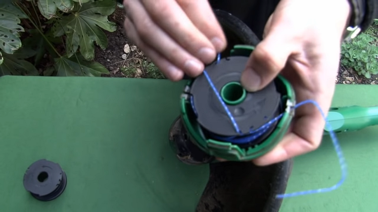 Removing Either Side Of The Line From The Spool Cleats And Feeding Them Through The Slim Eyelet Openings On Either Side Of The Cover