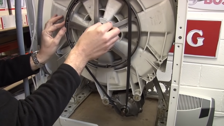 Remove the drive belt that wraps around the pulley wheel at the back of the machine.
