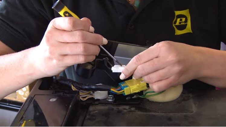 Using A Small Flat Blade Screwdriver To Gently Ease Out The Sensor Plug