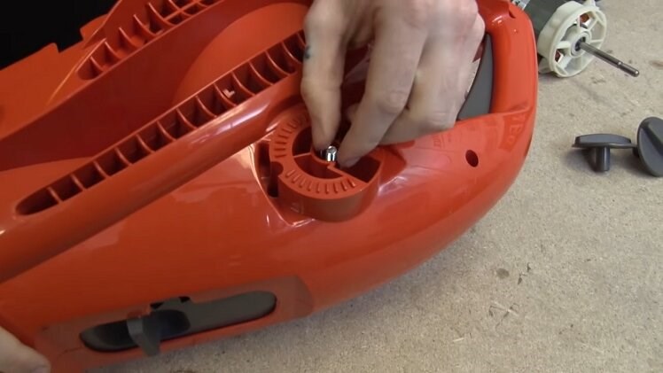 Pulling Out The Screws Beneath The Caps On Either Side Of The Garden Vacuum